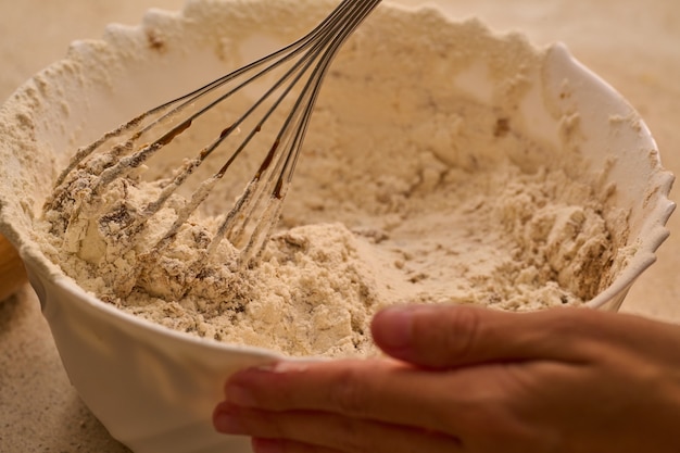 Mix di miscelazione per l'uomo di pan di zenzero di natale che cucina l'impasto