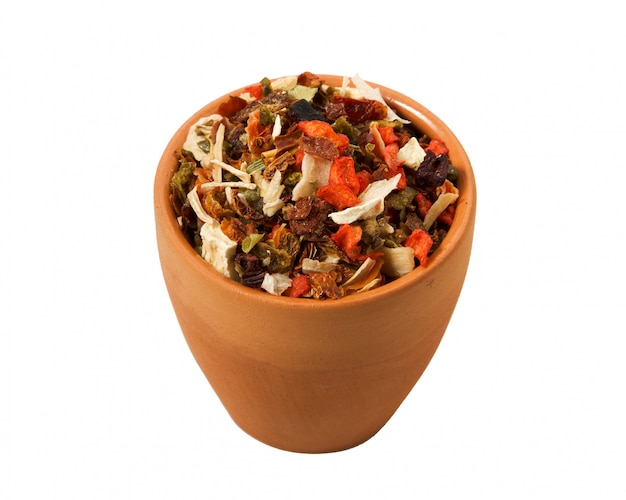 Mixing slices of pepper in a clay cup on a white background. 