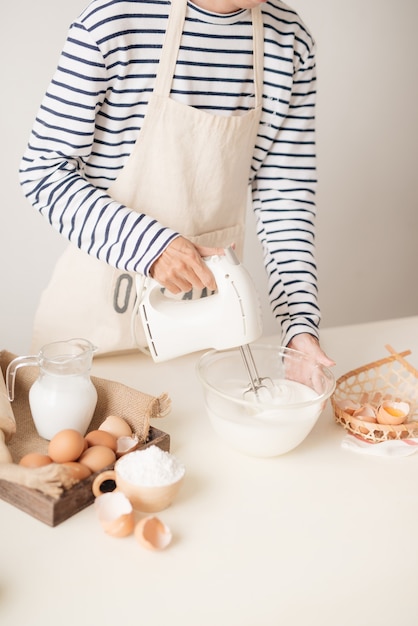 Mixing white egg cream in bowl with motor mixer