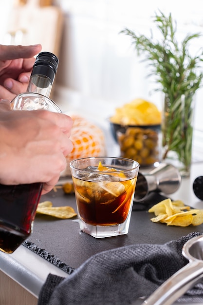 Mixologist making refreshing cocktail with vermouth at home