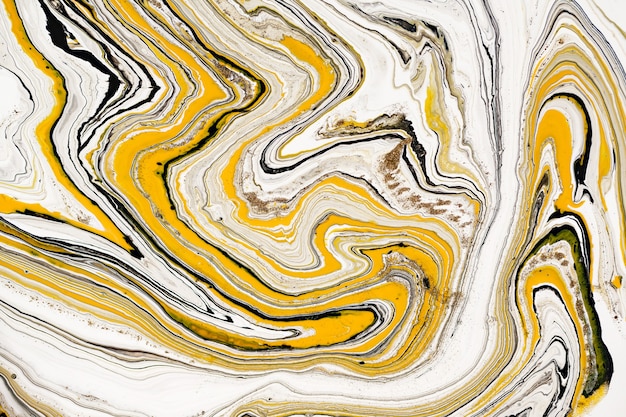 Mixture of acrylic paints. Modern artwork. Yellow and black mixed acrylic paints. Liquid marble texture.