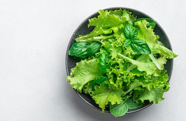 A mixture of healthy greens in a plate on a gray background diet food