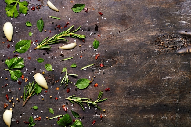 Mixture of herbs and seasonings on a wooden background