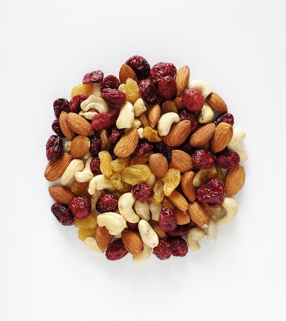 Mixture of nuts and dried berries isolated on white background. Copy space, top view, close-up.