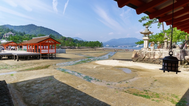 MIYAJIMA, JAPAN - SEPTEMBER 2016: Toeristen lopen op het strand bij eb bij Itsukushima-schrijn