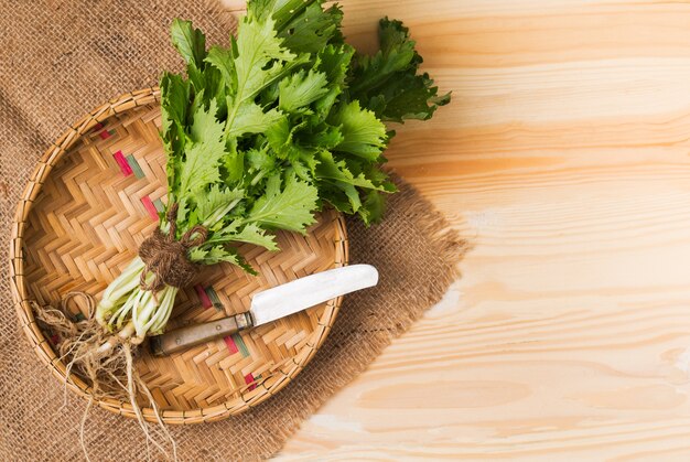 mizuna vegetation in basket and wood background