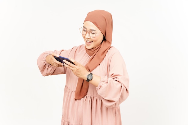 Mobiel spel spelen op smartphone van mooie aziatische vrouw die hijab draagt die op wit wordt geïsoleerd