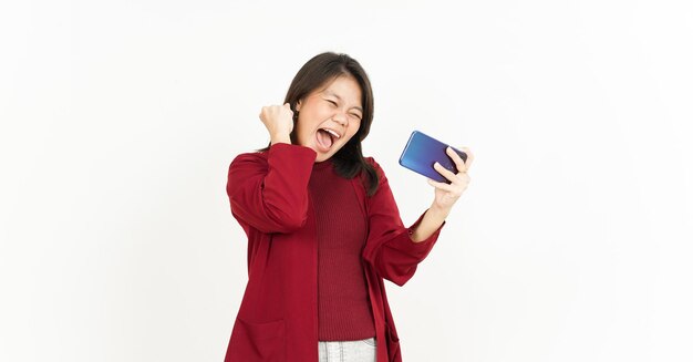 Mobiel spel spelen op smartphone van mooie Aziatische vrouw met rood shirt geïsoleerd op wit