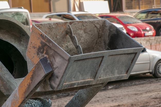 Mobiele betonmengmachine op de bouwplaats Closeup van grind dat in de betonmachine wordt geladen