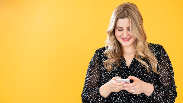 Mobiele communicatie Gadget mensen lichaam positief gewichtsverlies app gelukkig lachend overgewicht plus size zwaarlijvige vrouw met behulp van telefoon geïsoleerd op fel oranje kopie ruimte achtergrond