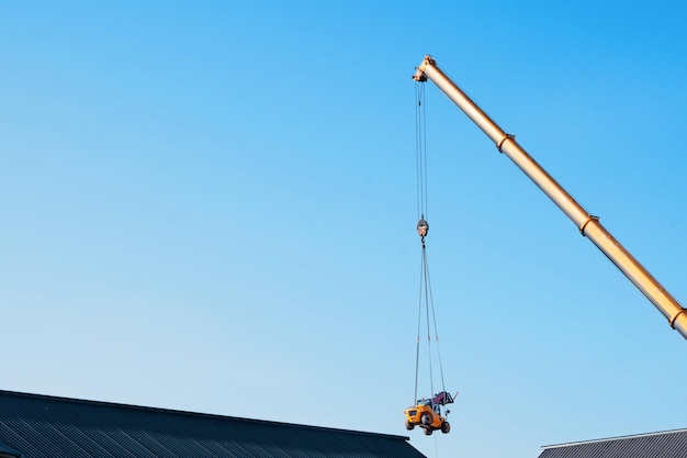 Mobiele kraan die verreiker boven het gebouw heft om hem in het werkgebied te plaatsen