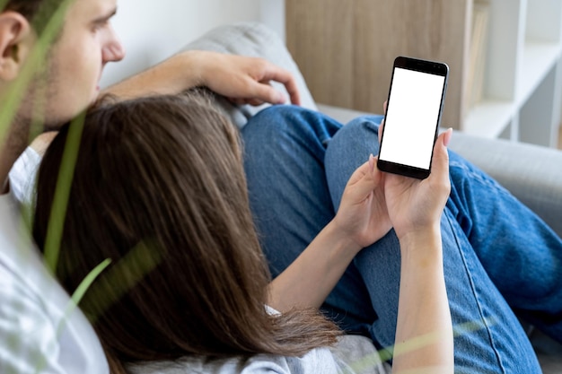 Mobiele mockup ontspannen paar online communicatie casual geliefde man en vrouw op zoek naar smartphone