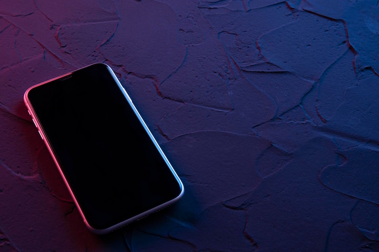 Foto mobiele smartphone op donkerrode blauwe neonkleuren. mock up.perspectief weergave. de indeling van het apparaat. presentatie van het interface-ontwerp.