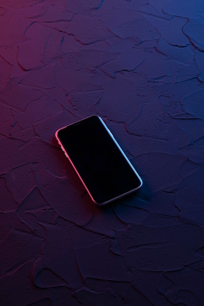 Mobiele smartphone op donkerrode blauwe neonkleuren. Mock up.Perspectief weergave. De indeling van het apparaat. Presentatie van het interface-ontwerp.