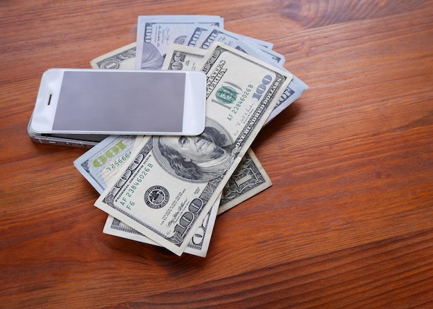 Mobiele telefoon en geld op een houten achtergrond