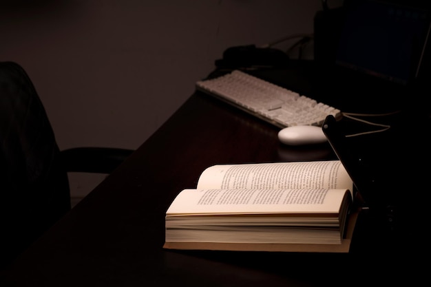 mobiele telefoon en powerbank op het bureau verlicht lees- en studieboek met computer op batterij