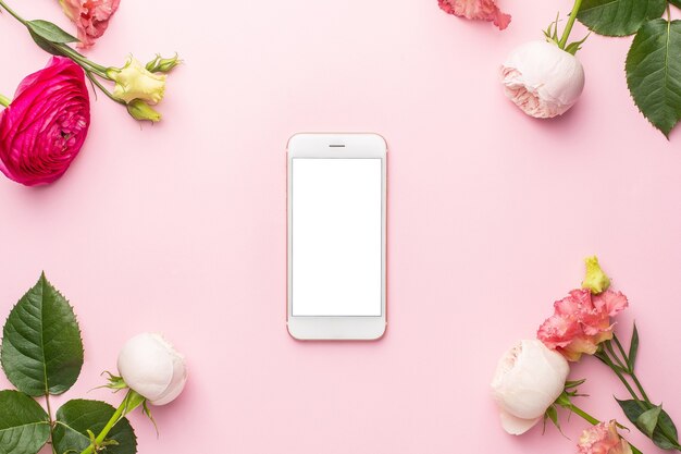 Foto mobiele telefoon en ranunculi roze bloemboeket