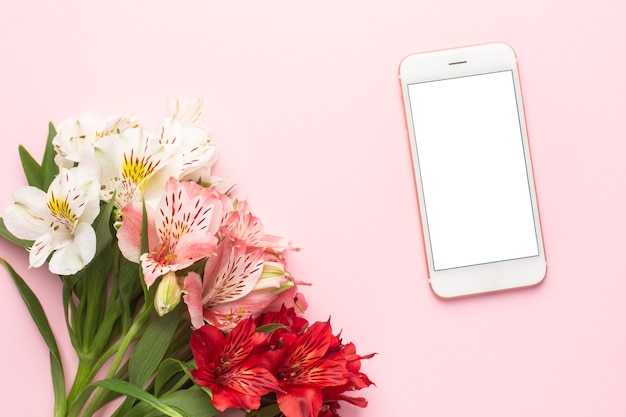 Mobiele telefoon en witte en roze bloem Alstroemeria op roze