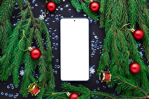 Mobiele telefoon met leeg scherm naast kerstversiering