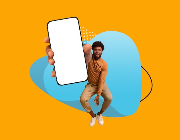 Mobile ad cheerful black man demonstrating big smartphone with blank screen