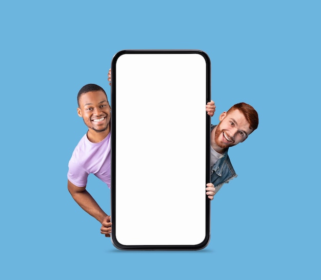 Mobile Ad Two Cheerful Men Peeking Out Behind Big Blank Smartphone