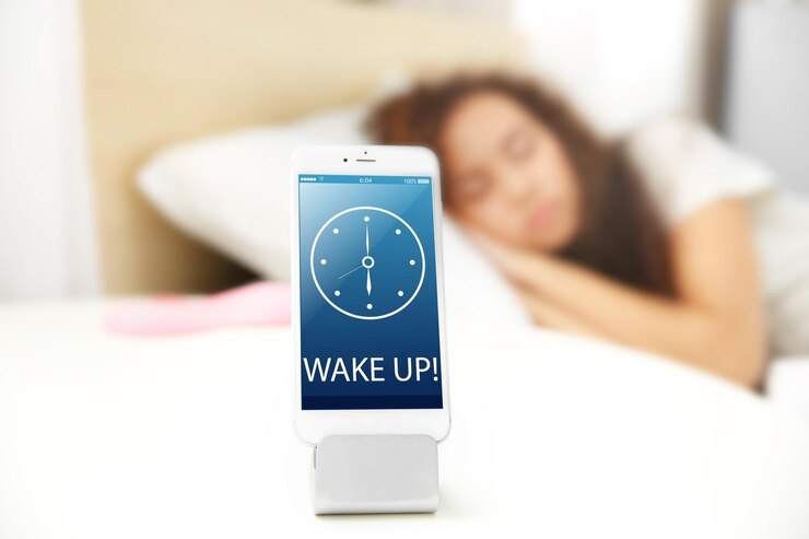 Mobile alarm clock and sleeping girl in bedroom