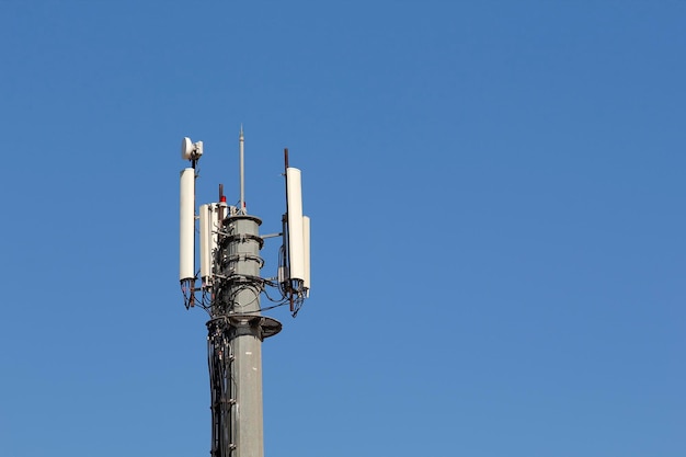 Photo mobile antenna in a tower against blue sky