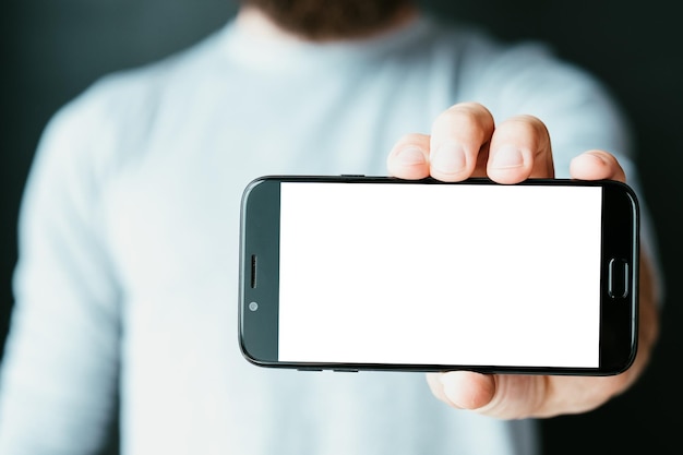 빈 흰색 화면이 있는 스마트폰을 들고 있는 모바일 앱 개발자 인터넷 기술 및 프로그래밍 스마트폰 소프트웨어 개발 남자