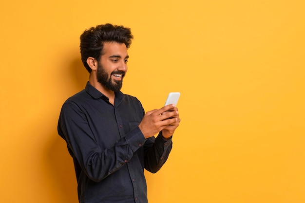 Mobile offer excited young indian man looking at smartphone screen