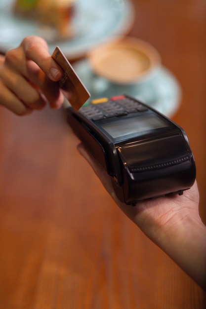 Mobile payment. Bank terminal hold by female hand and female hand with a credit or debit card to make payments