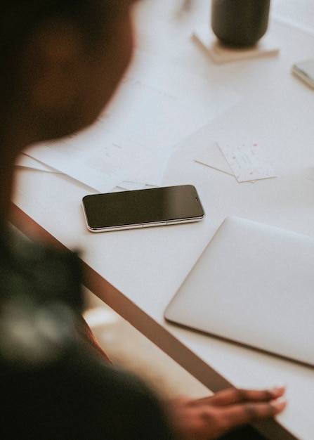 Mobile phone by a laptop on a table