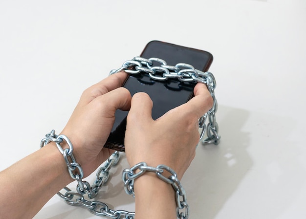 Mobile phone chained social media concept to the hands telephone