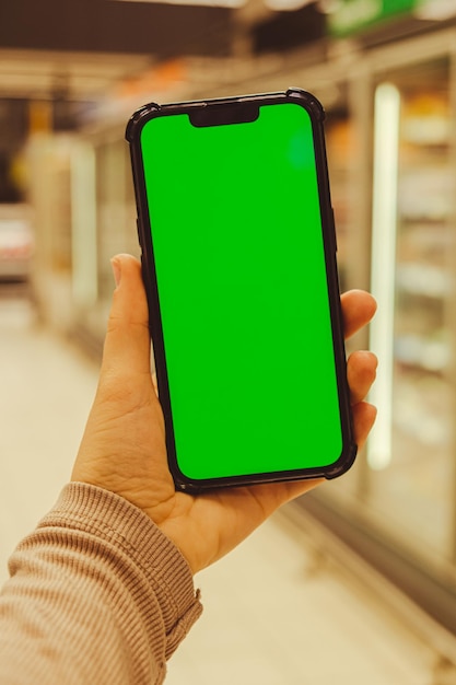 휴대 전화 모바일 앱 응용 프로그램용 크로마 키 스마트 폰을 들고 있는 여성의 손 클로즈업