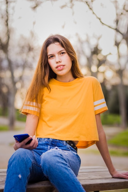 携帯電話通信技術 魅力的なヒスパニック系若い女性 オンライン接続 カジュアルな服を着て コピースペースを備えた屋外