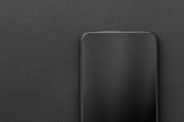 Фото Деталь мобильного телефона на черном плоском макете смартфона в качестве шаблона приложения и маркетингового дизайна бренда
