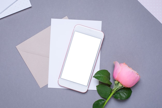 Photo mobile phone and envelope with pink rose on gray