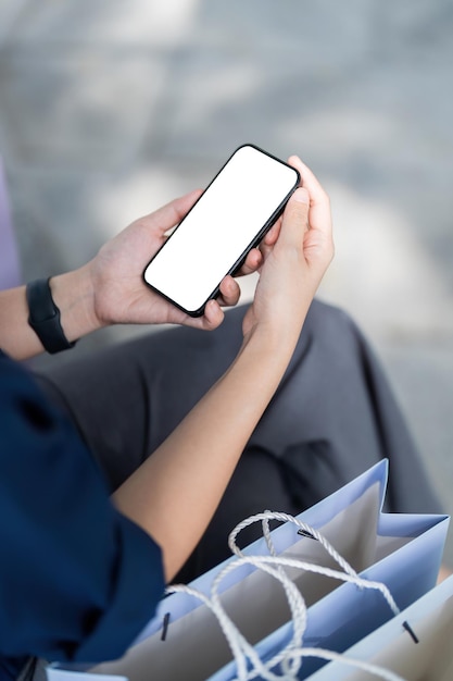 Mobile phone female hand holding in shopping mall Concept of shopping Black Friday sale