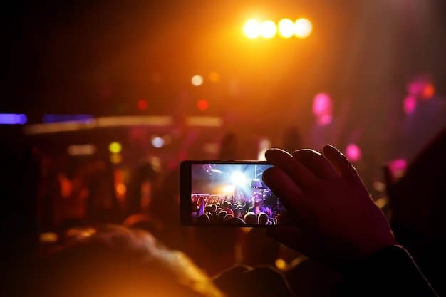 Mobile phone in hands at a music show Using a smartphone concept