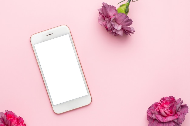 Mobile phone and Lilac flowers carnation on pink