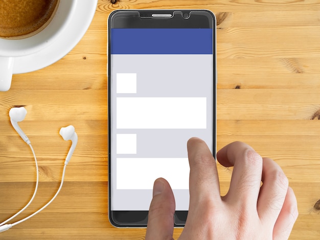 Mobile phone mockup with social network theme on screen and touching finger.