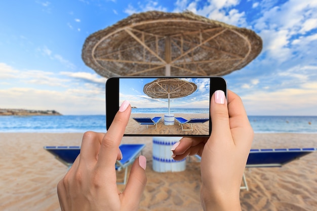 해변 와이드 뷰 가로의 휴대 전화 사진입니다. 근접 촬영 손 잡고 전화 촬영 해변