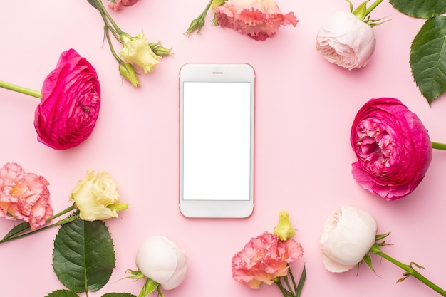 Foto telefono cellulare e bouquet di fiori rosa ranuncoli