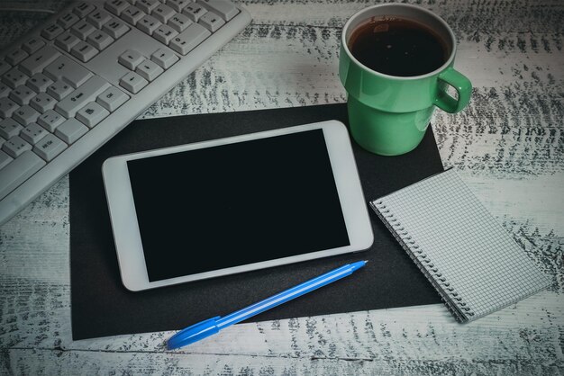 Mobile phone screen with important messages on desk with coffee\
pen paprclips and keyboard crutial information on cellphone on\
table with cup late updates presented