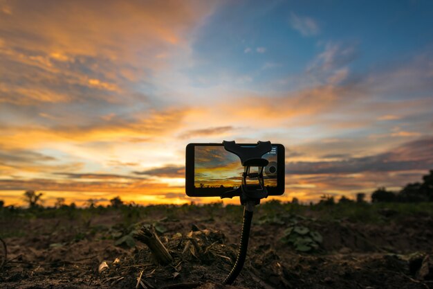 Foto di tiro del cellulare e time-lapse cielo al tramonto di bel colore