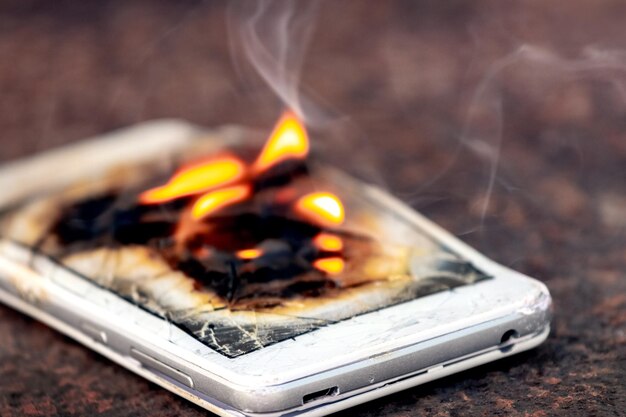 Mobile phone smartphone on fire burning smartphone