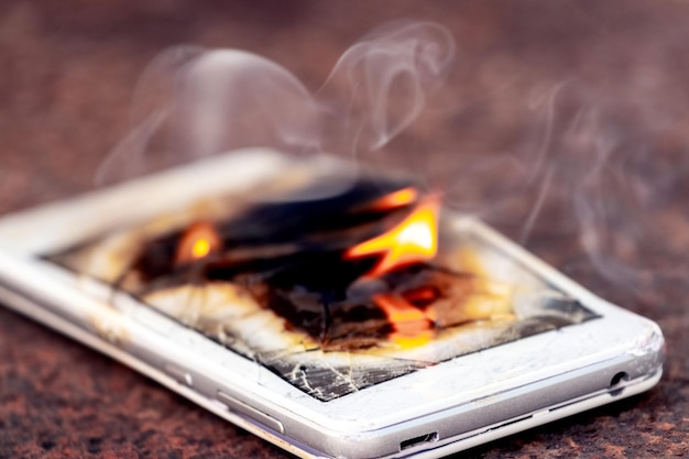 Mobile phone smartphone on fire burning smartphone