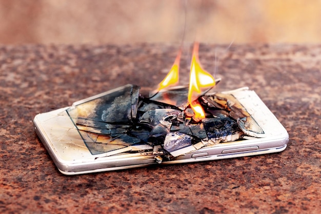 Mobile phone smartphone on fire burning smartphone