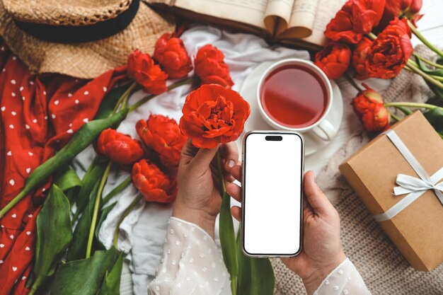 Photo mobile phone and spring flower tulips on a festive background theme of love mother's day women's day flat lay