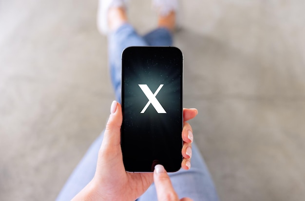Фото Мобильный телефон с буквой x на экране, специально изготовленный шрифт, не товарный знак