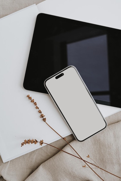 mobile phone with blank screen tablet pad dried grass on beige crumpled cloth aesthetic neutral beige template for social media mobile website with copy space for mock up